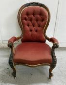 A mahogany button backed nursing chair on cabriole legs and with castors.