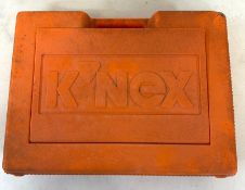A box of loose K'nex building pieces in an orange carry case