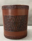 A brown leather embossed waste paper bin