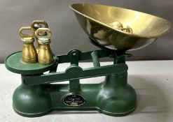 A vintage Salter kitchen scales in green cast iron with a brass scoop weight present