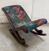 An oak gout stool with floral upholstery