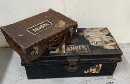 A metal trunk with vintage travel stickers along with a crocodile suitcase.