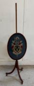 A mahogany pole screen with a glazed crest embroidery