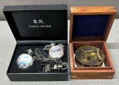 A replica sundial in a wooden box with a collection of pocket watches and a whistle