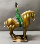 A Sancai or three colour glazed figure of a horse and ride H37cm