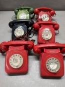 Four red, one green, one black dial telephone