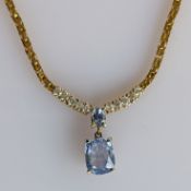An Italian blue topaz integrated pendant necklace on a 9ct yellow gold fancy-link chain with lobster