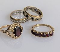 A yellow gold oval sapphire dress ring in a claw setting; a sapphire-set half-hoop eternity ring and