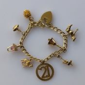 A yellow gold flat-curb-link bracelet with heart-shape locket, hallmarked 18ct, with eight 9ct gold 