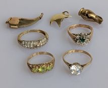 Four gem-set yellow gold rings, one with stones missing, and three gold charms, one damaged, all hal