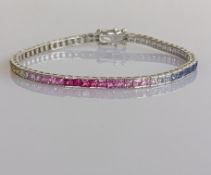 A white gold tennis or friendship bracelet with approximately 67 multi-coloured gemstones, 17.5 cm,