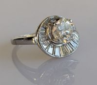 An Art Deco diamond cluster ring on a platinum setting, the central natural round brilliant diamond