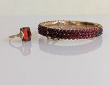 An early 20th century pave-set garnet hinged bangle on a yellow gold setting, 50mm, unmarked