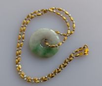 A Chinese jade disc pendant on a white and yellow gold chain, stamped 916, 40 cm, chain 7.9g