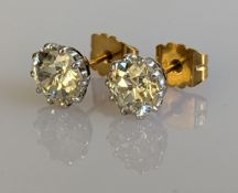 A pair of natural old European-cut diamond solitaire stud earrings in a white metal claw setting 