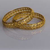A pair of elaborately pierced yellow gold bangles, each approximately 65mm, hallmarked for Birmingha