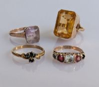An emerald-cut citrine dress ring, another amethyst dress ring, unmarked; a graduated gem-set ring