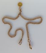 A yellow gold flat curb-link watch chain with twin lobster clasps, hallmarked, and a gold one dollar