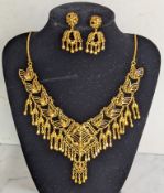 An Indian gold choker or bib necklace with elaborate pierced leaf and pendant bead decoration with m