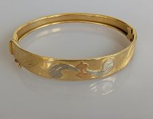 An Italian tri-gold bangle with applied and etched decoration, 65mm, hallmarked 750, 17.7g