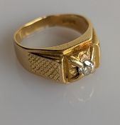 A yellow gold pinkie ring with textured panels and diamond decoration, the round cut diamond approxi