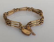 An early 20th century yellow gold gate-link bracelet with heart-shape clasp, 17 cm, hallmarked 9ct,