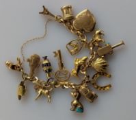 An Italian yellow gold link bracelet, hallmarked 750, 49.4g, with eighteen charms attached: two hall