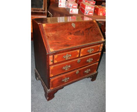 A small 19th century mahogany bureau with inlaid bats wing corners and line detail, the fall enclosing four drawers and pigeo