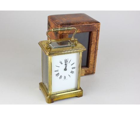 A brass and bevelled glass cased carriage clock, the white enamel face with Roman numerals marked made in France, in leather 