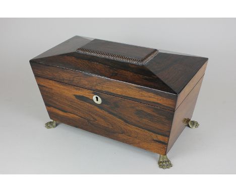 A George III rosewood tea caddy, sarcophagus shape, with fitted boxes and covers, recess for mixing glass (not present), on b