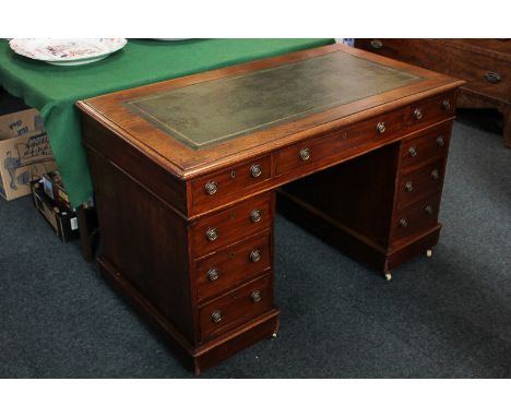 A Victorian mahogany pedestal desk with green leather inset top above an arrangement of nine various drawers with ring handle