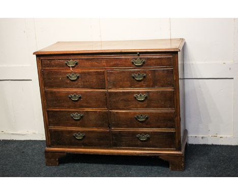 A 19th century Continental fruit wood chest with frieze drawer and brushing slide above two rows of four short drawers, on br