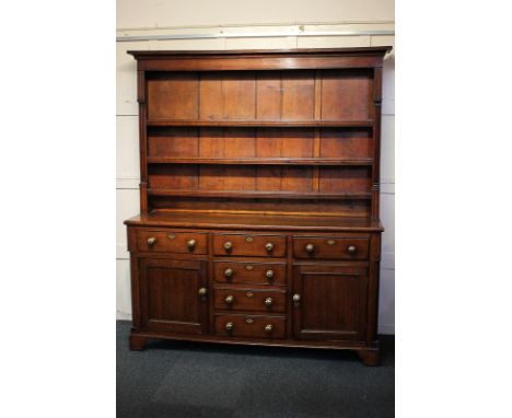 A 19th century oak dresser with three-shelf back above base with four central drawers flanked by two further drawers and cupb