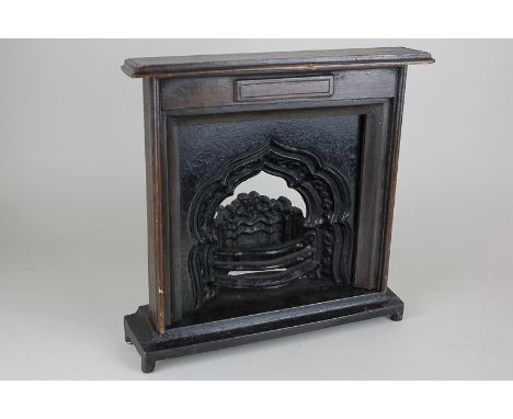 A cast iron miniature fireplace with mahogany surround, 29cm square