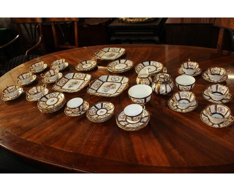 A Paragon China part tea service decorated with gilt laurel panels of floral sprays within blue and gilt borders, eleven tea 