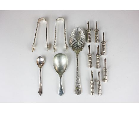 Four pairs of white metal corn spikes, two sugar tongs, a silver plated caddy spoon, mustard spoon and another spoon