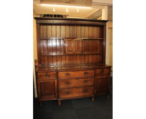 A Victorian oak Welsh dresser with two shelf and central cupboard back, above break front base with three central drawers fla