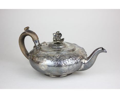 A George IV Paul Storr silver teapot of compressed circular shape embossed with flowers, handle cast as a flower, maker Paul 