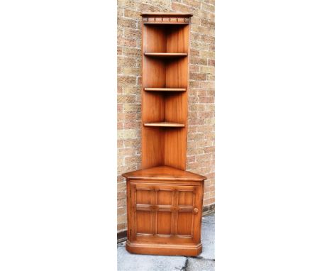 A PAIR OF ERCOL 'GOLDEN DAWN' OLD COLONIAL MURAL CORNER SHELF UNITS with handed cupboard bases (one opening left, one opening