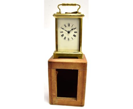 A BRASS CASED CARRIAGE CLOCK  the enamel dial with Roman numerals, the movement stamped 'FRANCE', with original carrying case