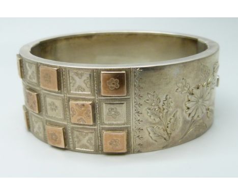 A Victorian white metal bangle with applied gold decoration, 36g, 4.7 x 5.7cm, 2.5cm wide