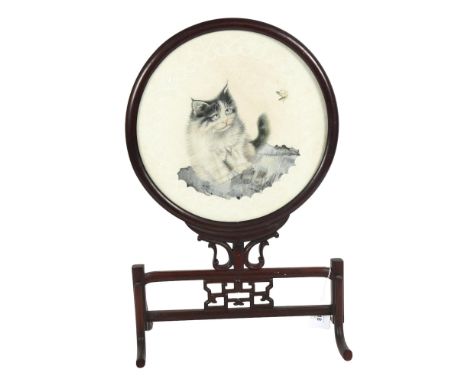 A Chinese padauk wood framed revolving table screen, the circular panel having an inset silk work study of a cat, height 51cm