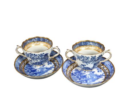 A pair of Chinese design blue and white cups and saucers, with gilded design 