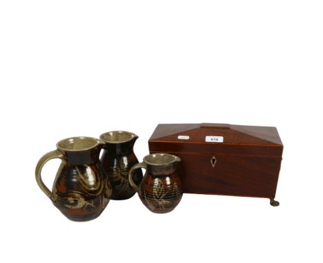 19th century sarcophagus tea caddy on brass paw feet, 29cm, and a graduated set of 3 glazed Studio pottery jugs 
