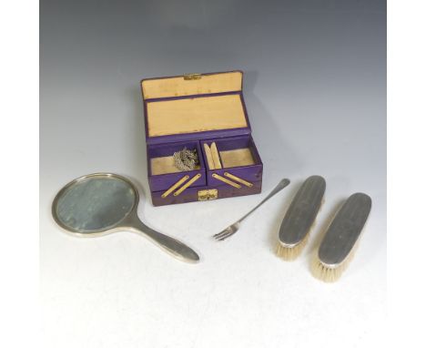 A silver backed Hand Mirror, hallmarked Birmingham 1919, together with a pair of corresponding brushes, all crested, a silver