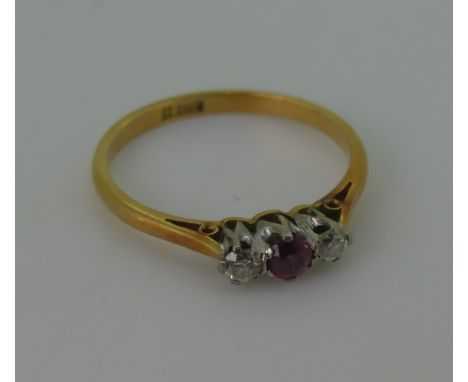 A small three stone ruby and diamond Ring,&nbsp;the circular pale ruby, approx 3mm diameter with a diamond on either side, al
