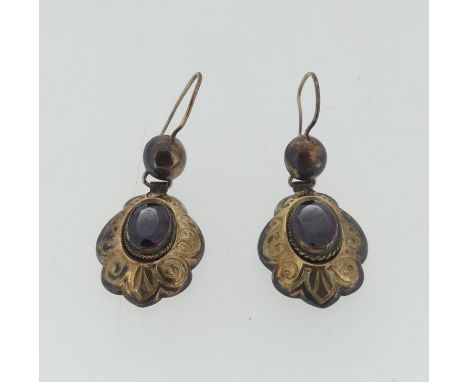 A pair of Victorian paste drop Earrings, the oval facetted stones within a shaped engraved surround, suspended from a ball dr