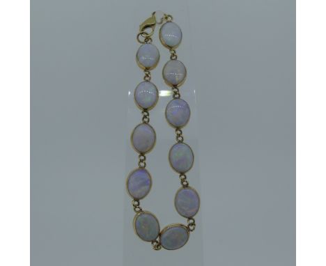 A 9ct gold and opal Bracelet,&nbsp;the eleven oval opals, each approx. 9.5mm long, collet set in 9ct gold, London hallmarks f