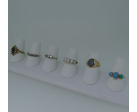 Six 9ct gold Rings; variously set including a three stone turquoise, unmarked but tested, opal, white paste, garnet and seed 