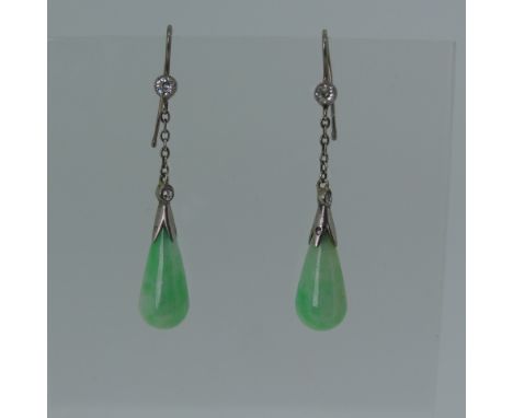 A pair of early 20thC Jade Earrings, the pear shaped drops in unmarked white metal with millegrain set diamond above on a fin